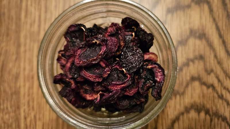 Close-up of dehydrated cherries stored in glass jar.