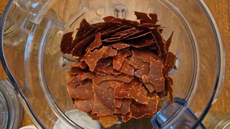 Top view of dehydrated pumpkin pieces placed inside a blender.