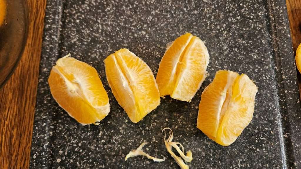 Orange cut into quarters after removing membranes, ready for freezing
