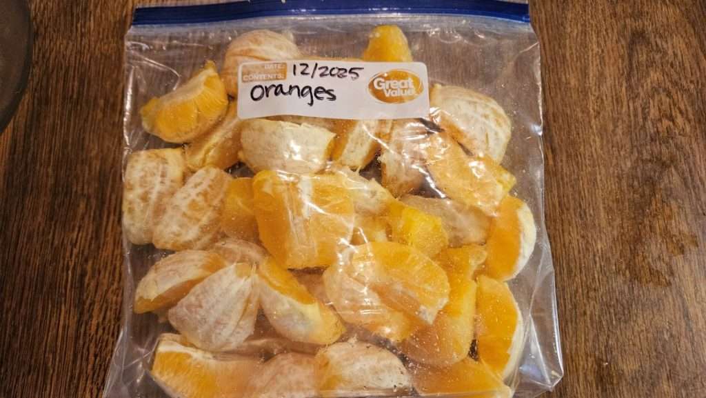 Labeled freezer bag filled with orange sections ready for freezer storage