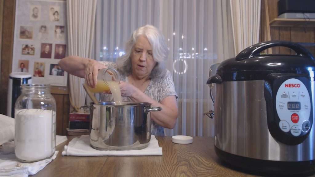 Pouring lemon juice into a stainless steel pot