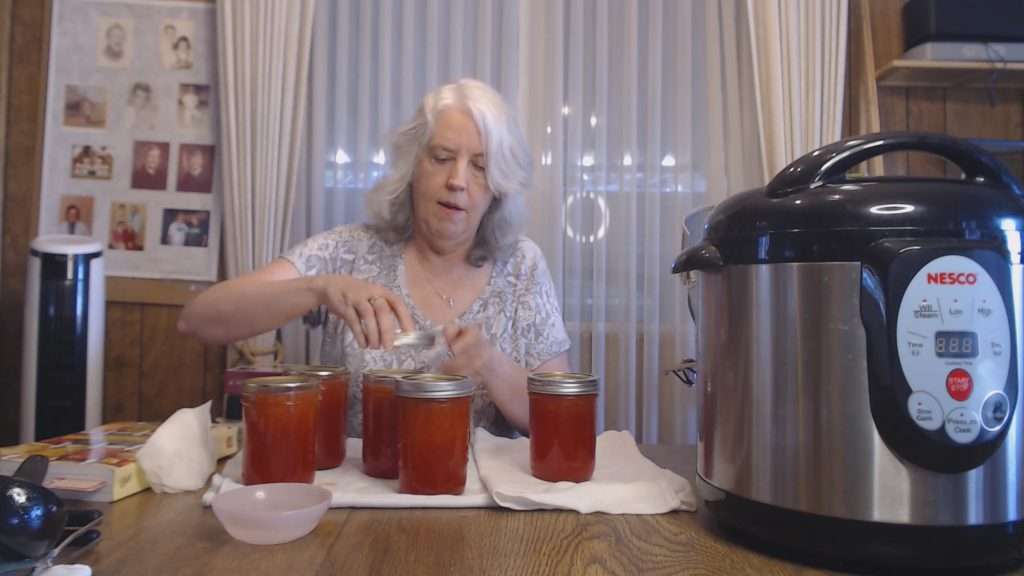 Putting the rings on filled canning jars