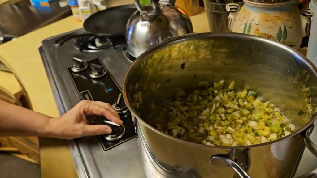Cooked tomatillo salsa in a stainless steel pot, ready to go into the canner.