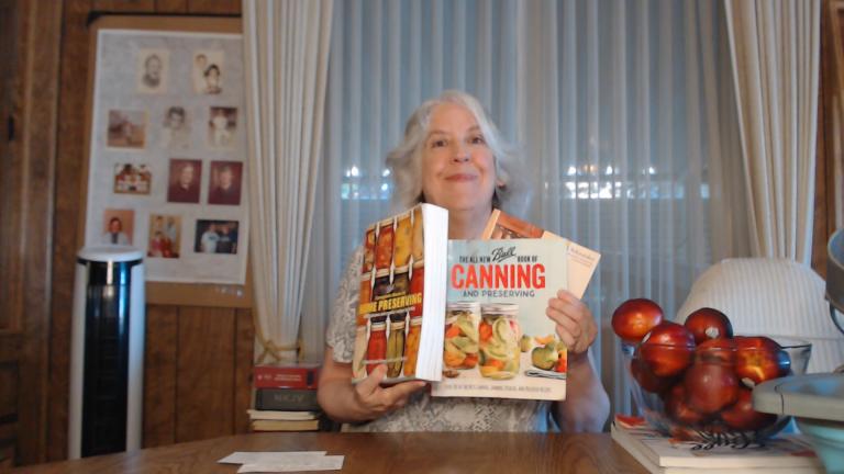 a photo of Rebecca Livermore holding up her 3 favorite canning books