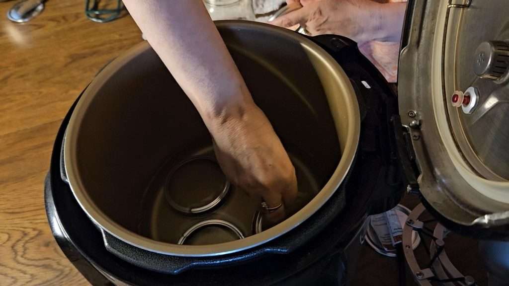 Putting canning rings on the bottom of the Nesco canner.