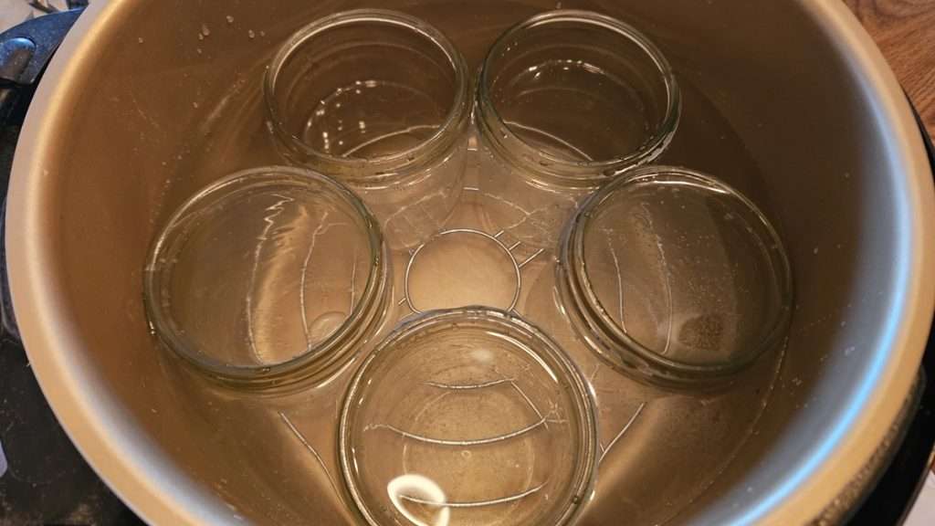 Nesco canner with 22 cups of water and 5 pints jars. This is the appropriate amount of water to use when heating jars for water bath canning in the Nesco.