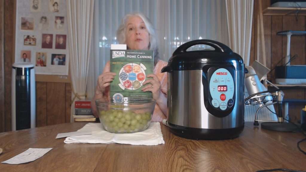 Rebecca Livermore holding up the USDA Complete Guide to Home Canning