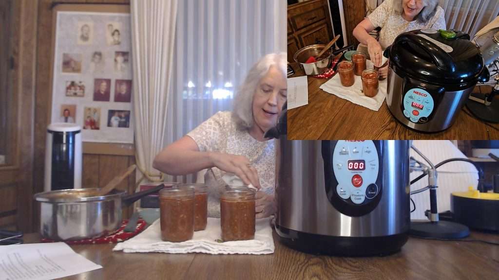 Wiping the rims of pint sized canning jars filled with sloppy joe mix.