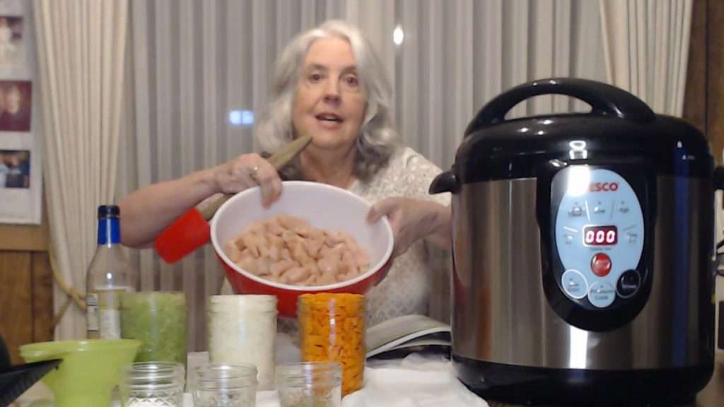 holding up ingredients needed for canning chicken and gravy in a jar.