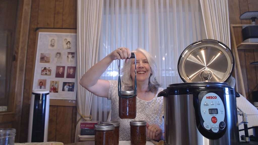 Holding up a jar of home canned sloppy joes