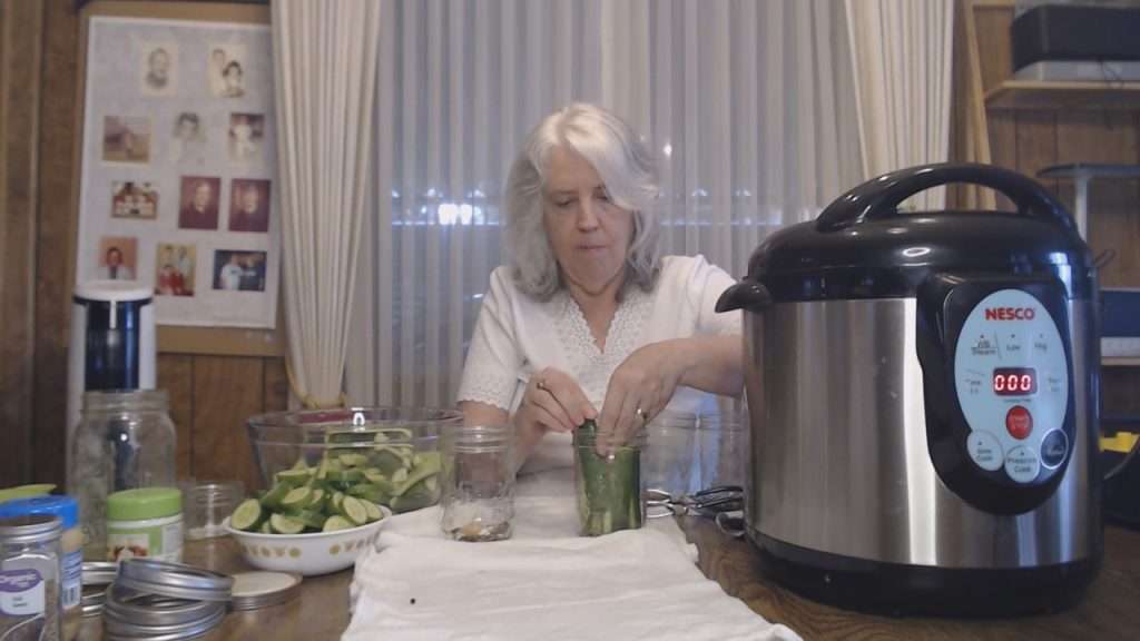 Packing cucumber spears into a canning jar.