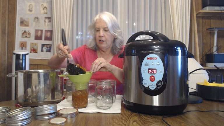 using a ladle to fill canning jars with chili con carne
