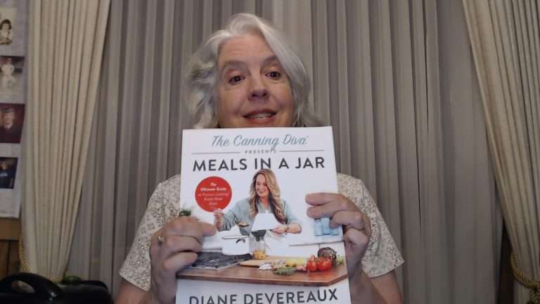 Holding up the book, The Canning Diva Presents Meals in a Jar