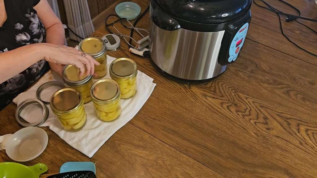 putting lids on pint canning jars filled with apples