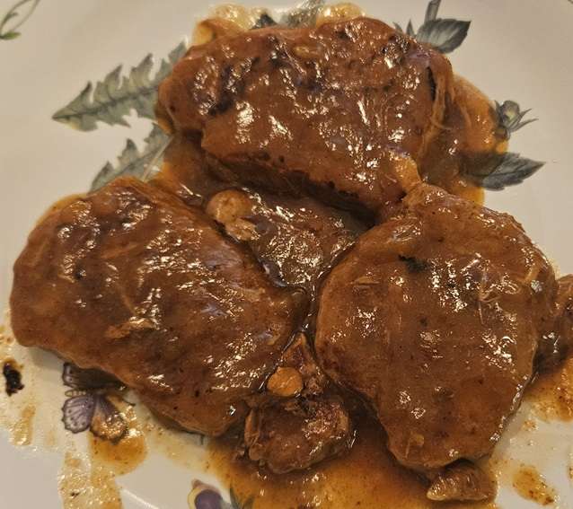 home canned pork chops in gravy on a plate.