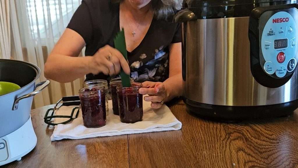 Debubbling cranberry sauce in canning jars.