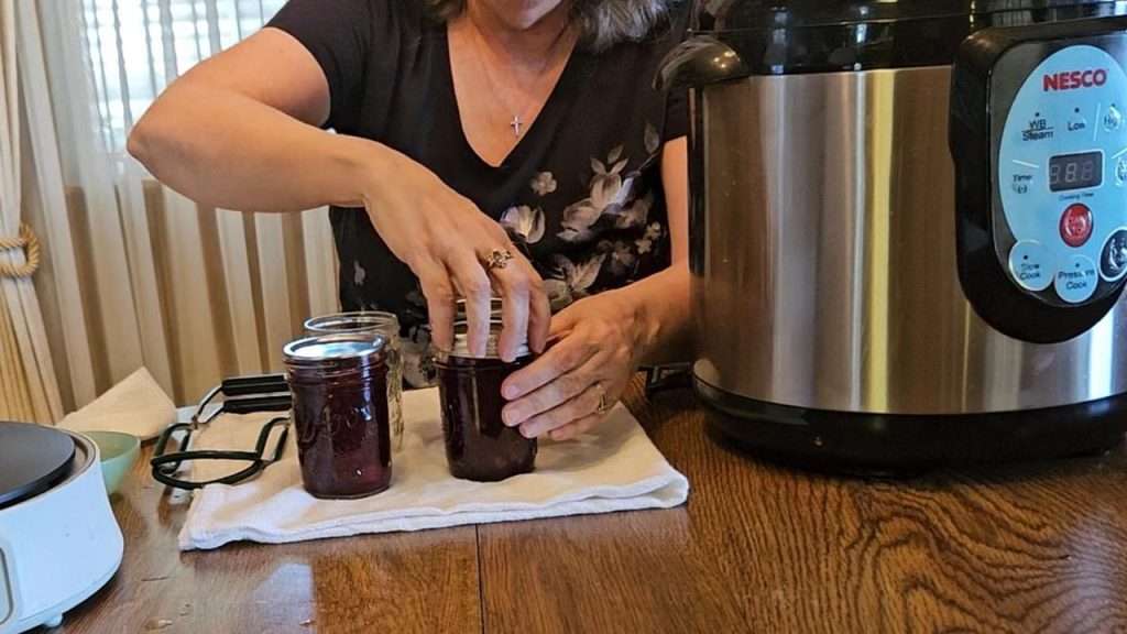 Putting the rings on jars filled with cranberry sauce.