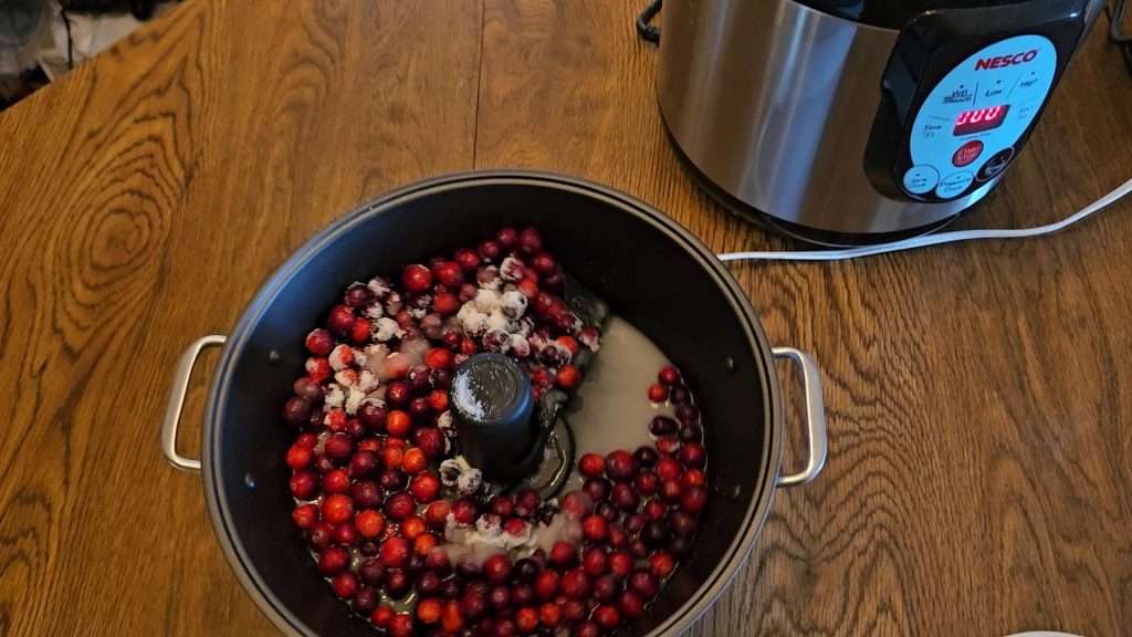 cranberries and sugar in the ball jam and jelly maker for making cranberry sauce.