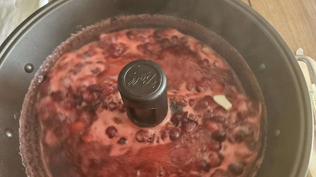 cranberry sauce in the jam maker starting to foam.