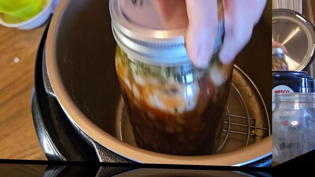 Putting a canning jar of beef stroganoff into the Nesco canner.
