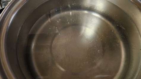 A stainless steel pot with syrup for canning fruit