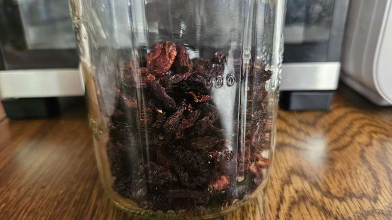 Glass jars of dried cherries filled about two-thirds full