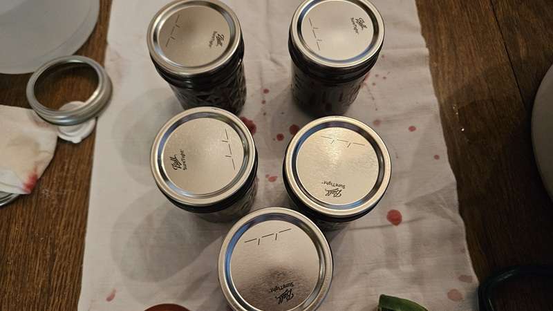 Jars of cherry jam with lids on.