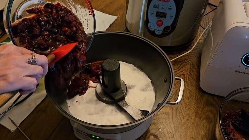 Adding cherries to the Ball jam and jelly maker.