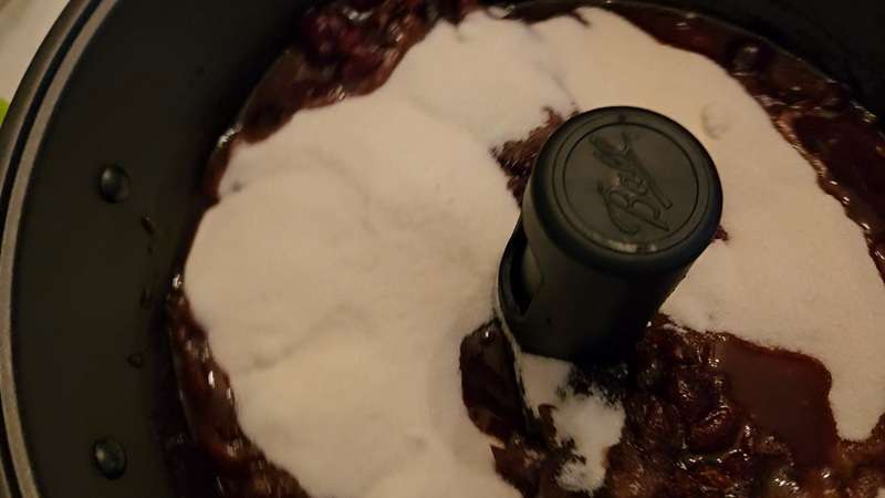Sugar on top of cherries in the jam maker.
