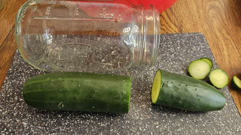 A cucumber with part cut off to make it the right size to fit into a mason jar.
