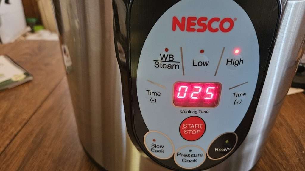 The Nesco canner showing 25 minutes and high pressure selected on the display, which is the time needed to safely pressure can green beans.