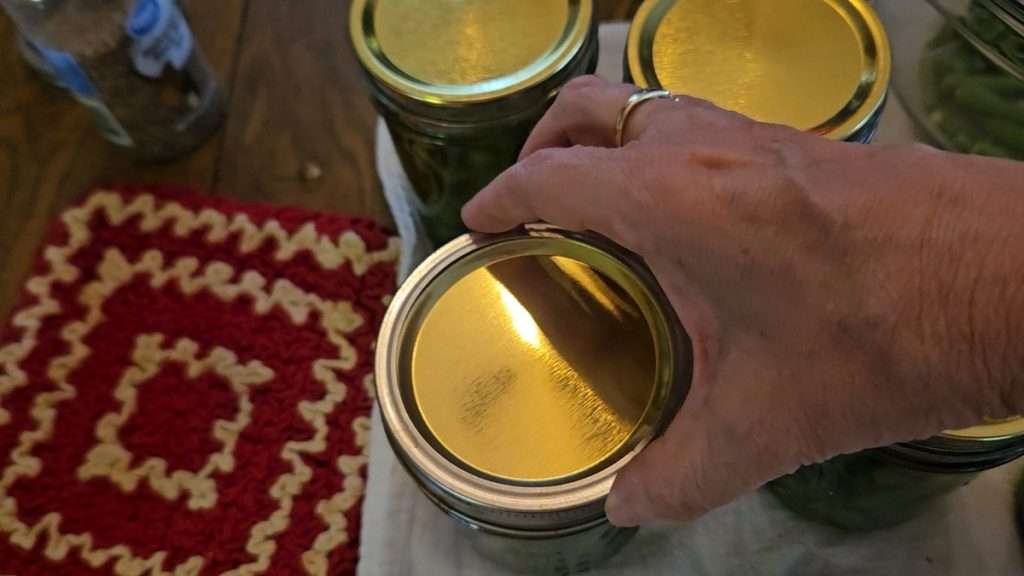 putting the canning ring on fingertip tight.