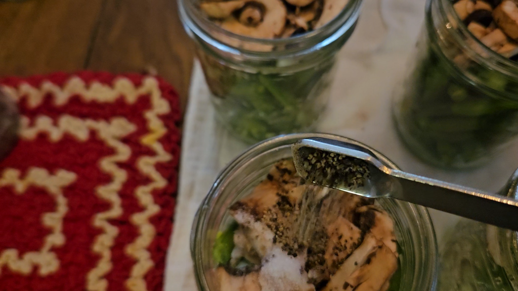 adding black pepper into the canning jar