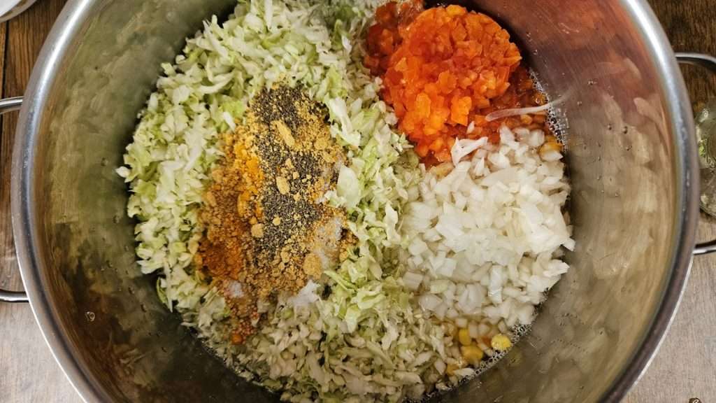 all of the ingredients for canning corn relish in a large stainless still pot, not stirred up.