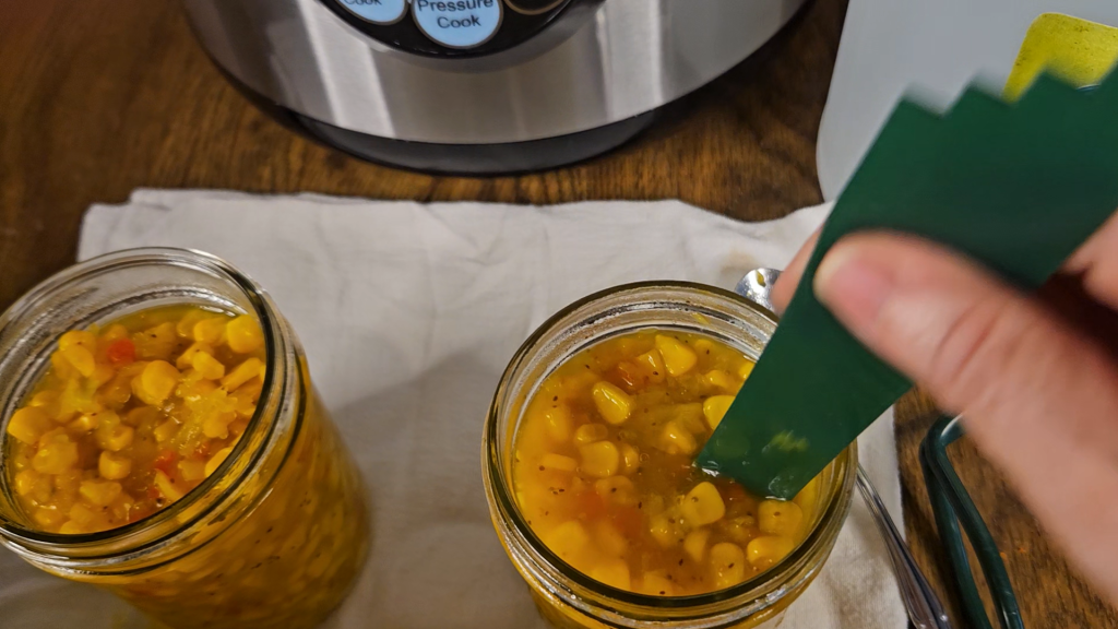 debubbling corn relish in mason jars.