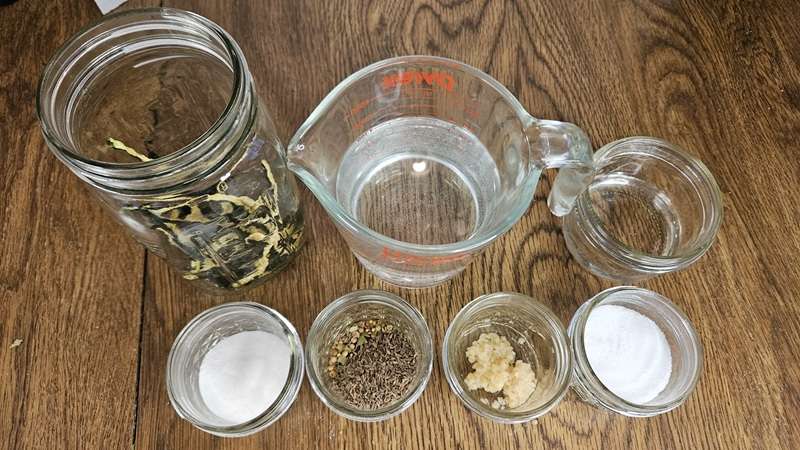 The ingredients for making refrigerator pickles with dehydrate cucumbers include dehydrated cucumbers, water, vinegar, sugar, pickling spice, dill seed, garlic, salt