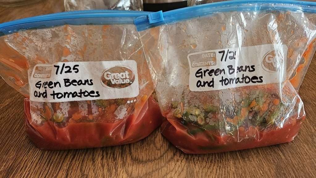 freezer bags with green beans and tomatoes. There is condensation on the bag, so they need to cool more before going into the freezer.