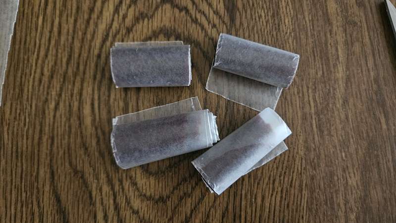 Cherry fruit leather rolled up in wax paper that has been cut into 1 1/2 to 2" pieces.