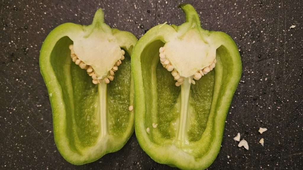 Bell pepper cut in half, with the seeds still intact.