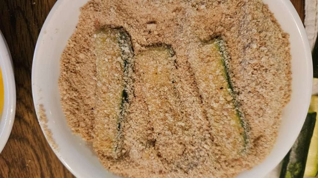 zucchini coated with breadcrumbs in a bowl.