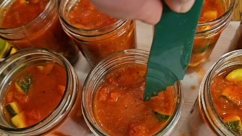 checking for 1" headspace on canning jars filled with zucchini and tomatoes