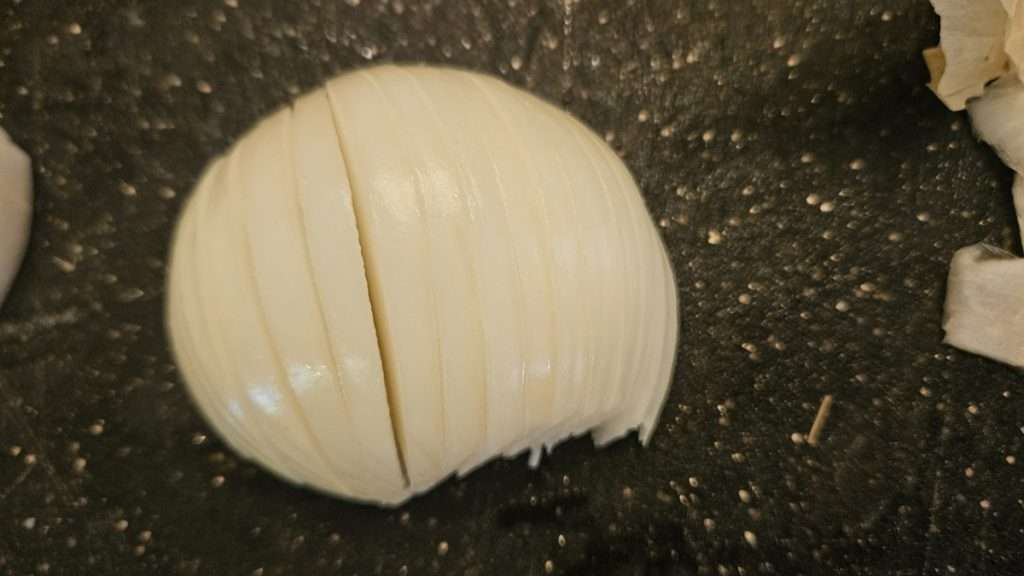 Half of an onion, cut side down, cut into slices.