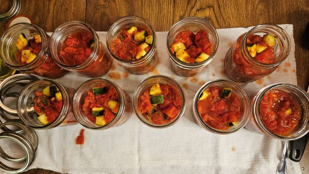 canning jars filled with zucchini and tomatoes