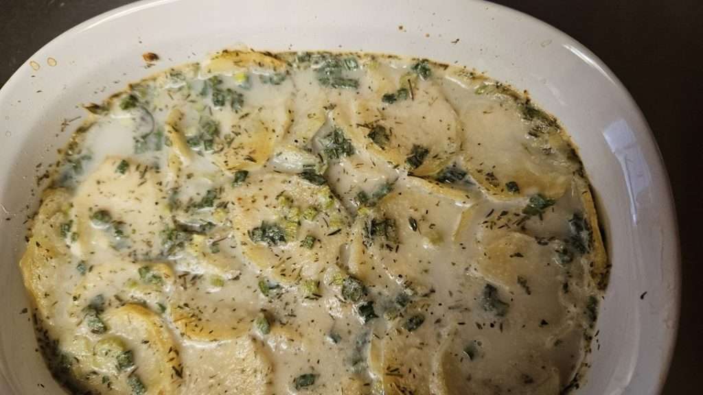 Partially cooked scalloped potatoes. They are slightly browned.