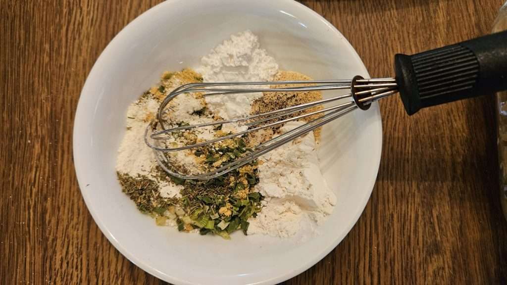 All of the dry ingredients in a bowl with a whisk in the bowl. I used a whisk to combine all of the dry ingredients.