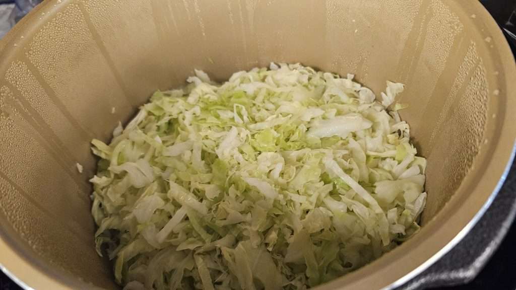 Steamed shredded cabbage inside Nesco canner after cooking.