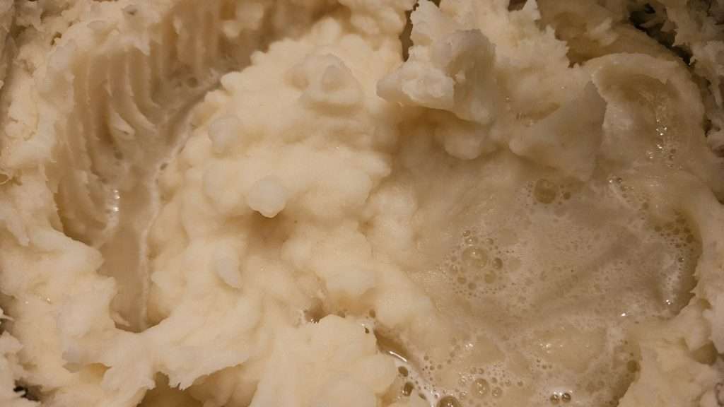 a pool of water sitting on top of mashed potatoes.