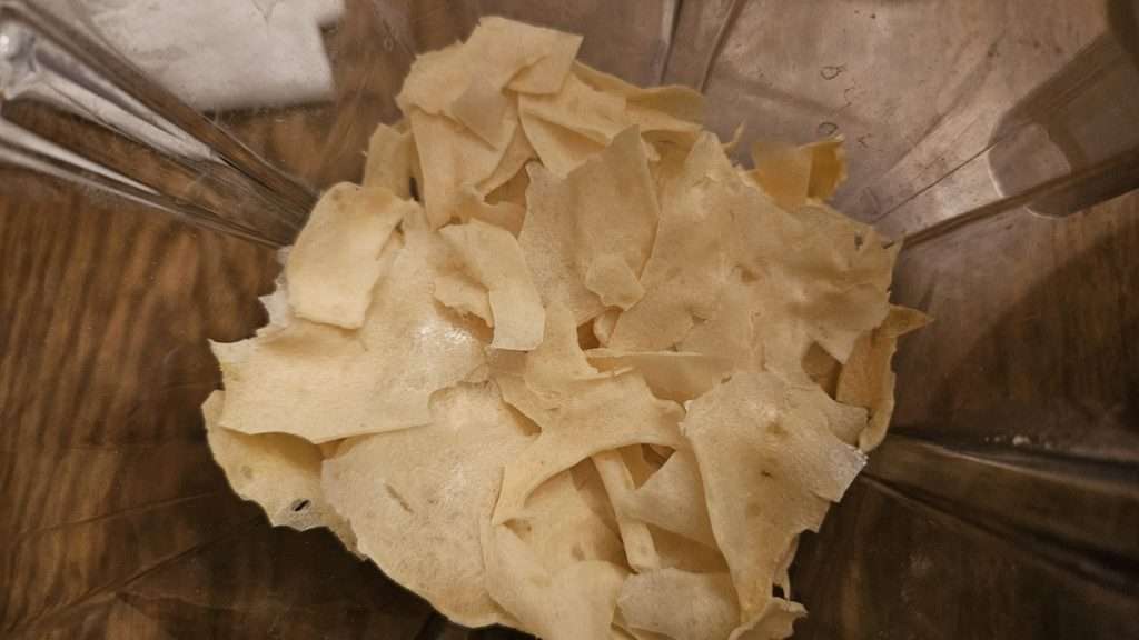 Broken pieces of dehydrated mashed potatoes in a blender, ready to grind.