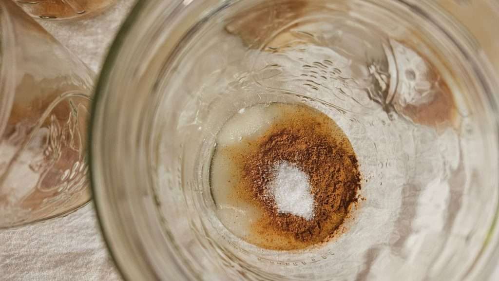 Overhead view of salt added to jar with other seasonings